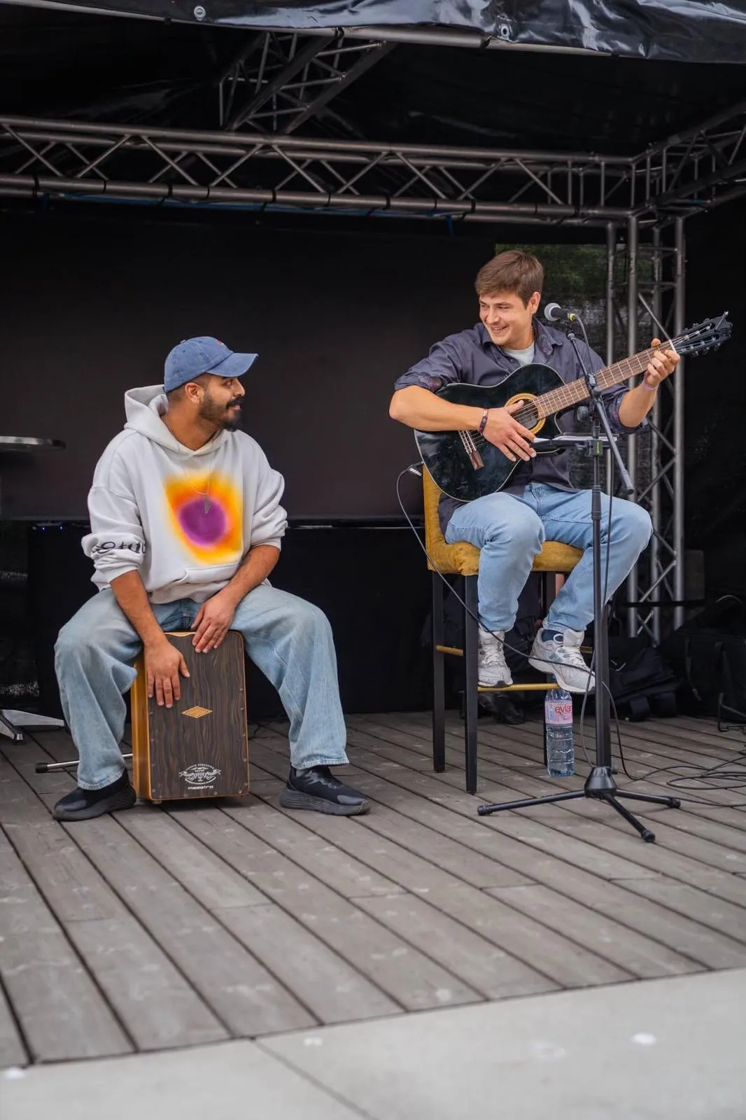 Habibi Hermanos live auf einer Bühne: einer am Cajón, einer mit Gitarre, beide lachen sich an